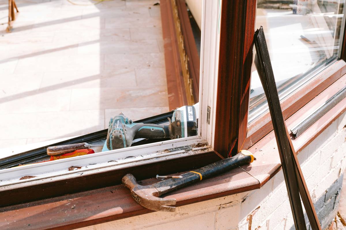 Assorted home hardware power tools including drill, circular saw, and impact driver on a workbench